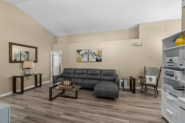 living room with baseboards, light wood-type flooring, and lofted ceiling