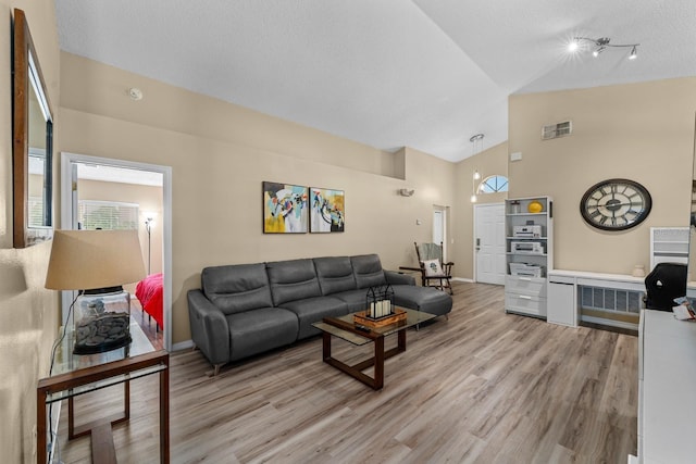 living room featuring light wood finished floors, visible vents, baseboards, high vaulted ceiling, and a textured ceiling