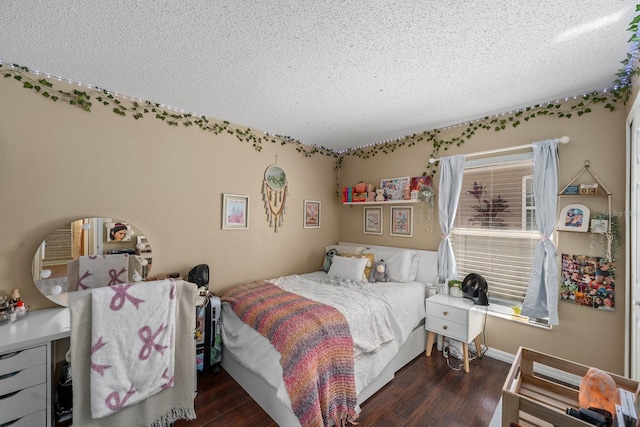 bedroom with a textured ceiling, baseboards, and wood finished floors