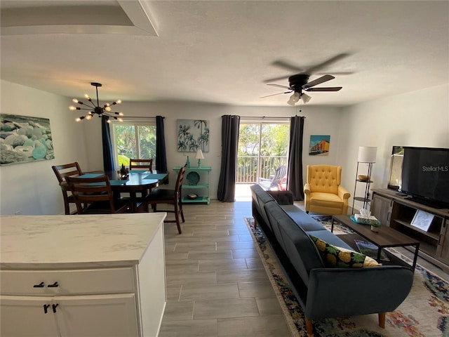 living area with plenty of natural light and ceiling fan with notable chandelier