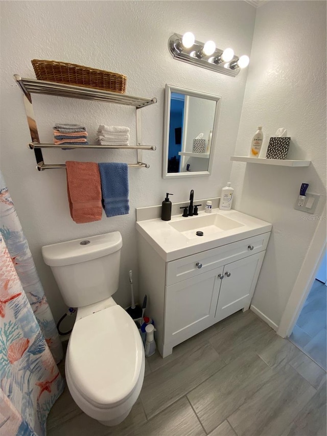 full bathroom featuring toilet, vanity, and wood finished floors