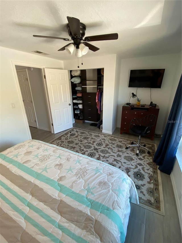 bedroom featuring a closet, visible vents, a textured ceiling, and ceiling fan