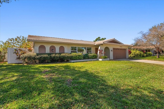 view of front of house with an attached garage, a tile roof, driveway, and a front yard