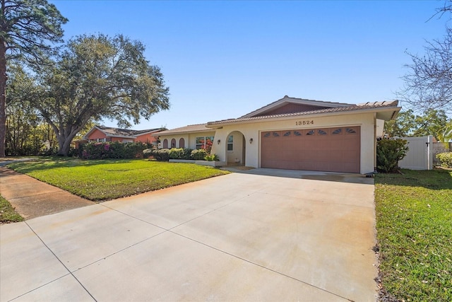 ranch-style home with stucco siding, concrete driveway, a front yard, and a tile roof