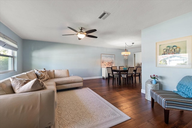 living room featuring baseboards, dark wood-style floors, visible vents, and ceiling fan