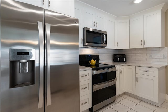 kitchen with light stone counters, light tile patterned floors, backsplash, and stainless steel appliances