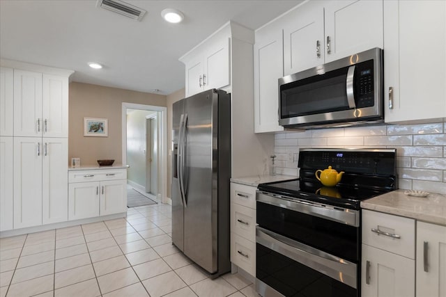 kitchen with visible vents, backsplash, appliances with stainless steel finishes, white cabinets, and light tile patterned floors