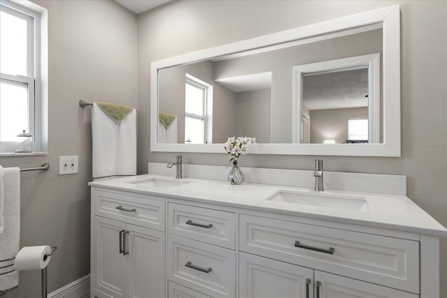 bathroom featuring double vanity, plenty of natural light, and a sink