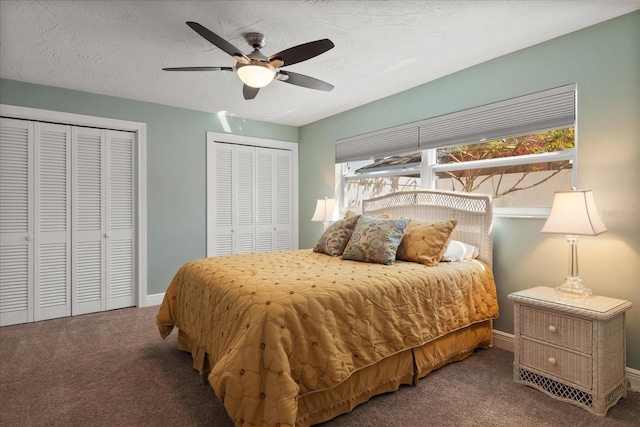 carpeted bedroom with baseboards, two closets, ceiling fan, and a textured ceiling