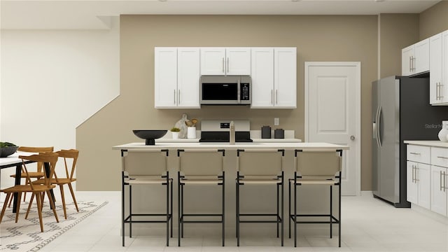 kitchen featuring white cabinets, appliances with stainless steel finishes, a breakfast bar, and light countertops