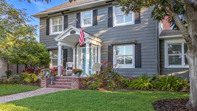 view of front of house with a front lawn and fence