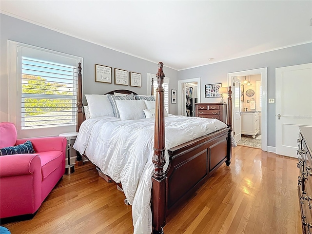 bedroom featuring light wood-type flooring, a closet, ensuite bath, and a spacious closet