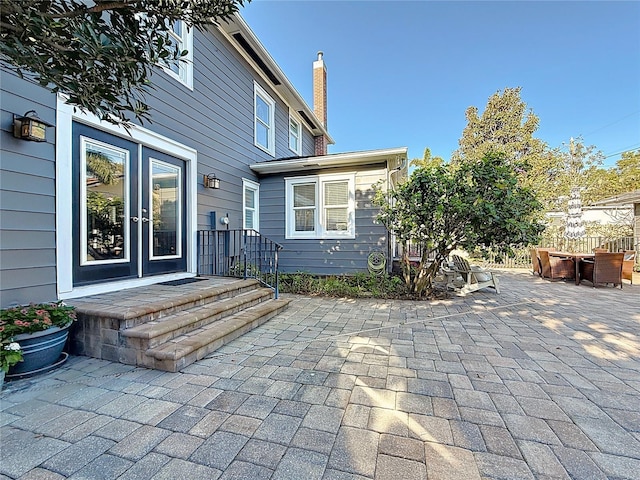 exterior space featuring french doors, a patio, and a chimney