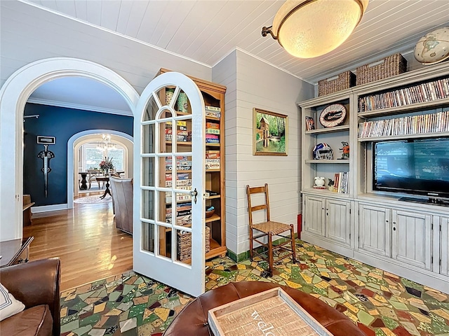 office space with wooden walls, crown molding, wood ceiling, wood finished floors, and arched walkways