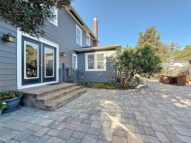 exterior space with french doors, a chimney, and a patio