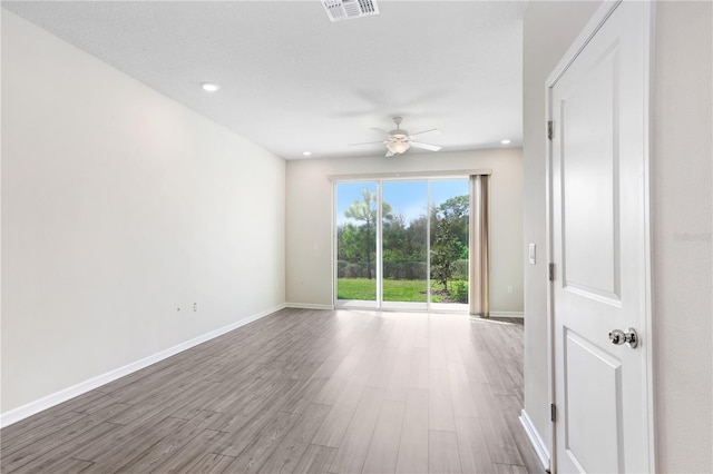 empty room featuring baseboards, wood finished floors, visible vents, and ceiling fan