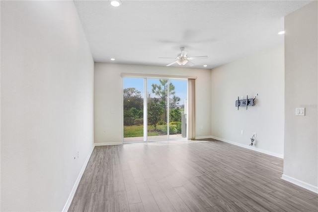 unfurnished room featuring recessed lighting, wood finished floors, baseboards, and ceiling fan