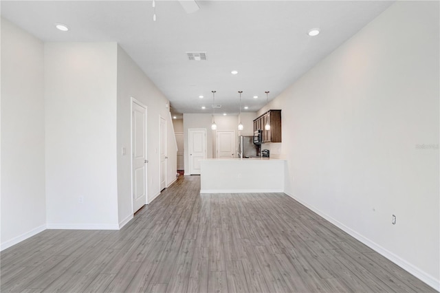 unfurnished living room featuring visible vents, a ceiling fan, recessed lighting, light wood finished floors, and baseboards