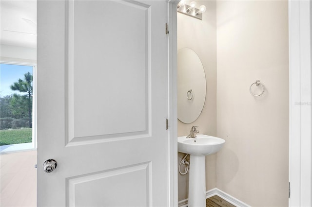 half bath featuring a sink and baseboards