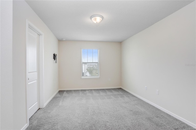 carpeted spare room with baseboards