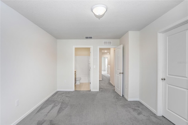 unfurnished bedroom with carpet, visible vents, and baseboards