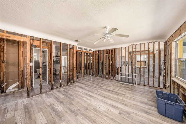 miscellaneous room featuring visible vents, a healthy amount of sunlight, a ceiling fan, and wood finished floors