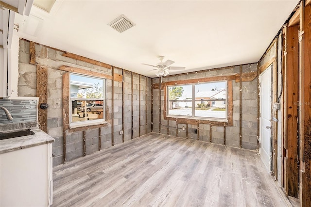 empty room featuring a ceiling fan, a healthy amount of sunlight, visible vents, and a sink