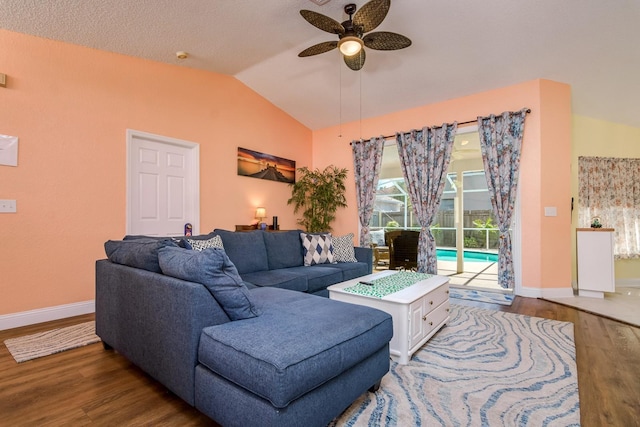 living area with baseboards, wood finished floors, a ceiling fan, and vaulted ceiling