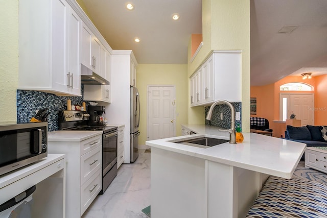 kitchen with a sink, white cabinets, under cabinet range hood, appliances with stainless steel finishes, and marble finish floor