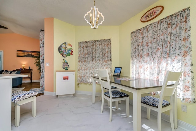 dining space with a notable chandelier, marble finish floor, and baseboards