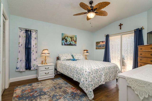 bedroom featuring dark wood-style floors, baseboards, lofted ceiling, access to exterior, and a textured ceiling