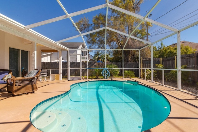 view of swimming pool featuring a patio area, a fenced in pool, glass enclosure, and a fenced backyard