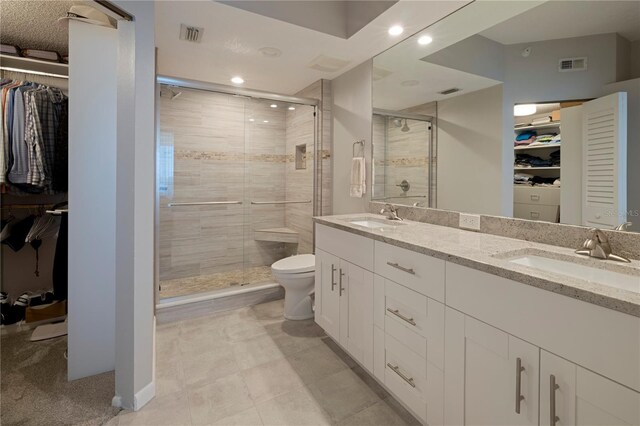 full bathroom featuring a stall shower, toilet, and a sink