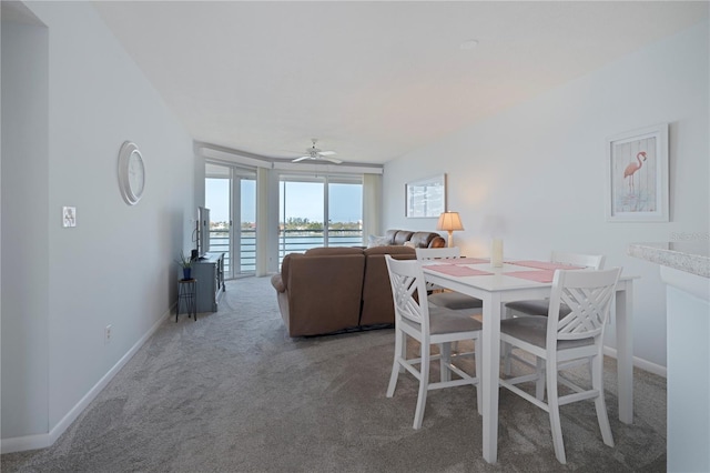 carpeted dining area featuring baseboards and ceiling fan