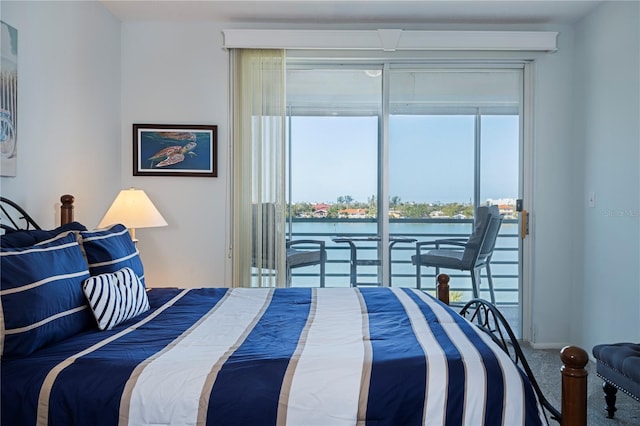 bedroom with access to outside, carpet flooring, and a water view