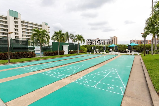 view of property's community with shuffleboard and fence