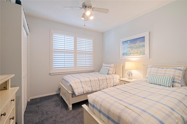 bedroom featuring dark colored carpet, baseboards, and a ceiling fan
