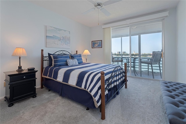carpeted bedroom featuring access to outside, a baseboard heating unit, a ceiling fan, and a water view
