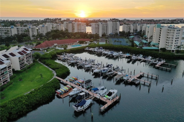 aerial view at dusk of a water view and view of marina