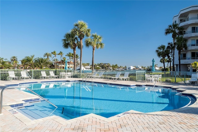 community pool with fence and a patio area