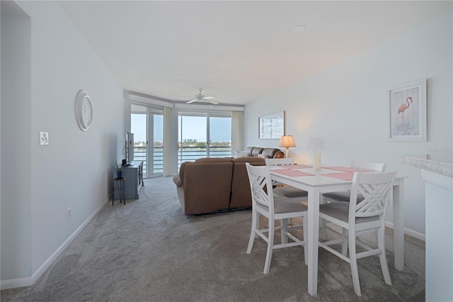 dining space featuring carpet floors, a ceiling fan, and baseboards