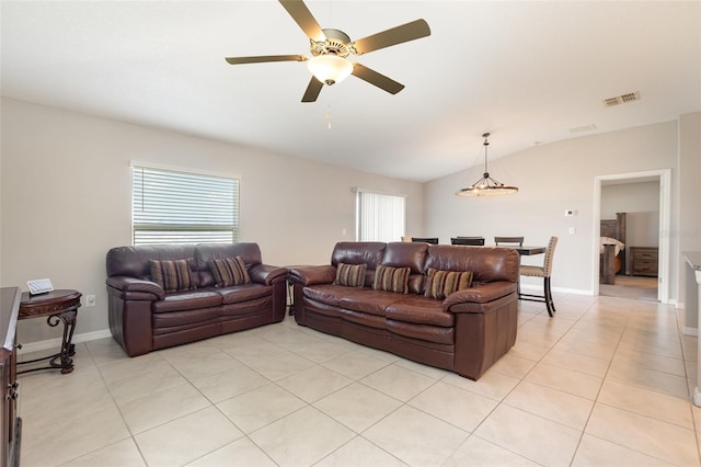 living room with visible vents, baseboards, ceiling fan, lofted ceiling, and light tile patterned floors