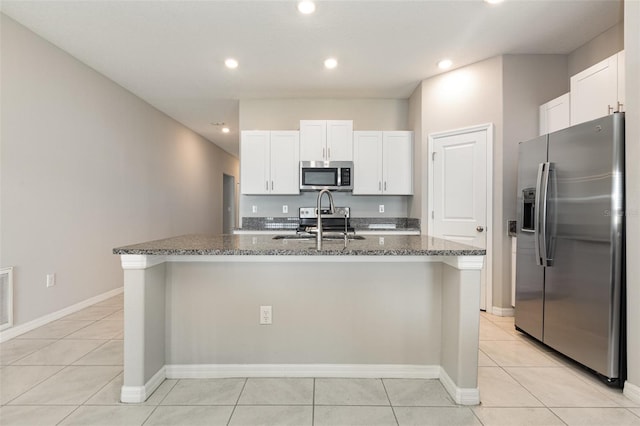 kitchen featuring a sink, stainless steel appliances, light tile patterned flooring, and white cabinets