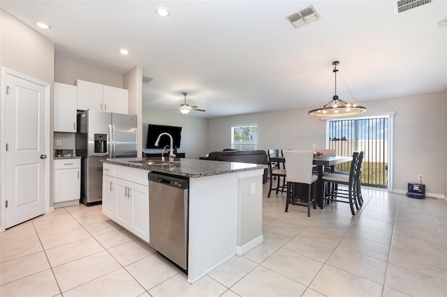 kitchen with a sink, an island with sink, visible vents, and stainless steel appliances