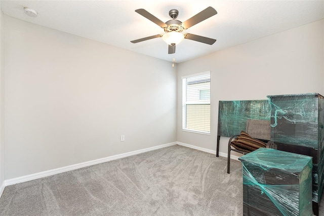 interior space featuring baseboards, a ceiling fan, and carpet flooring