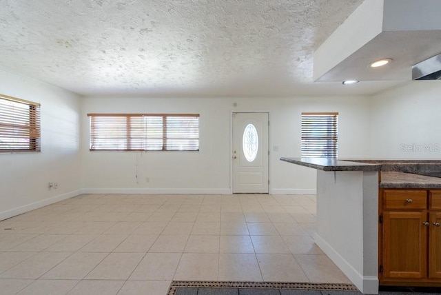 entrance foyer featuring light tile patterned floors, baseboards, a textured ceiling, and recessed lighting