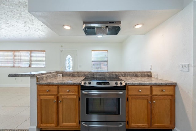 kitchen featuring stainless steel electric stove, a healthy amount of sunlight, and brown cabinetry