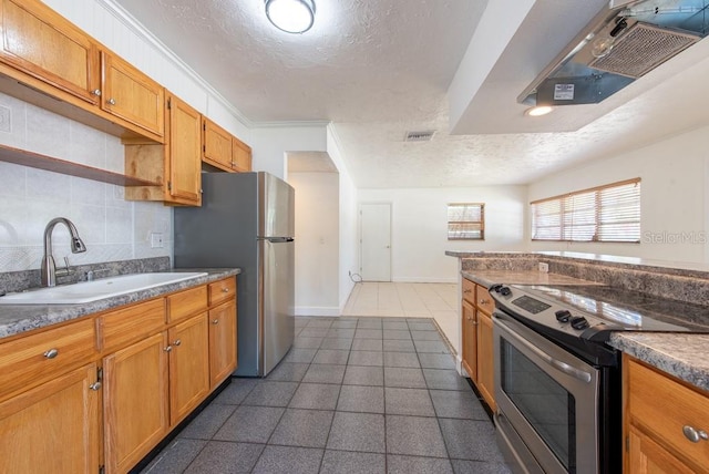 kitchen with visible vents, a sink, stainless steel appliances, a textured ceiling, and tasteful backsplash