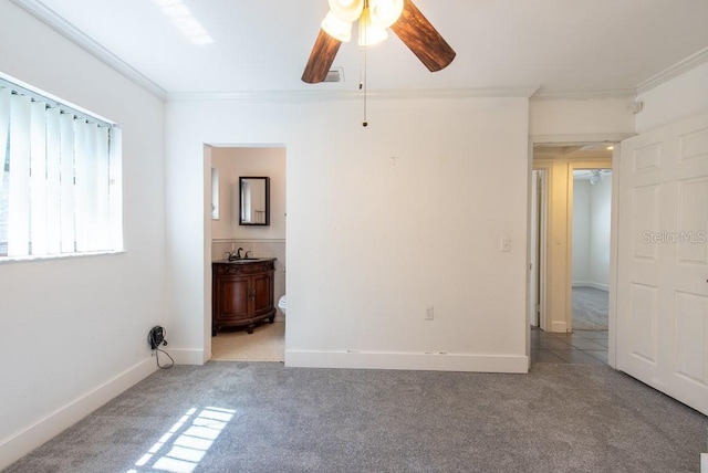 spare room with baseboards, a ceiling fan, light colored carpet, and ornamental molding