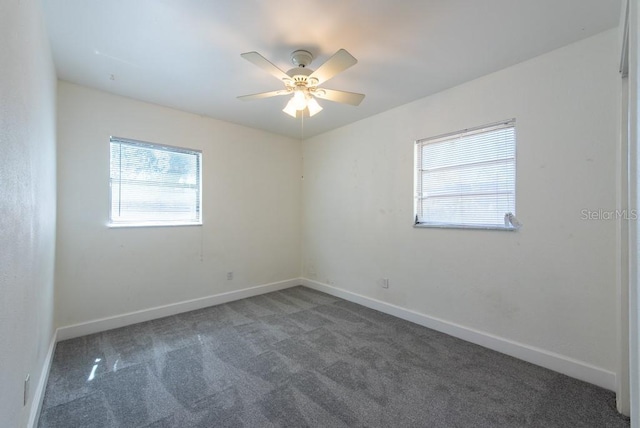 carpeted empty room featuring a healthy amount of sunlight, baseboards, and ceiling fan